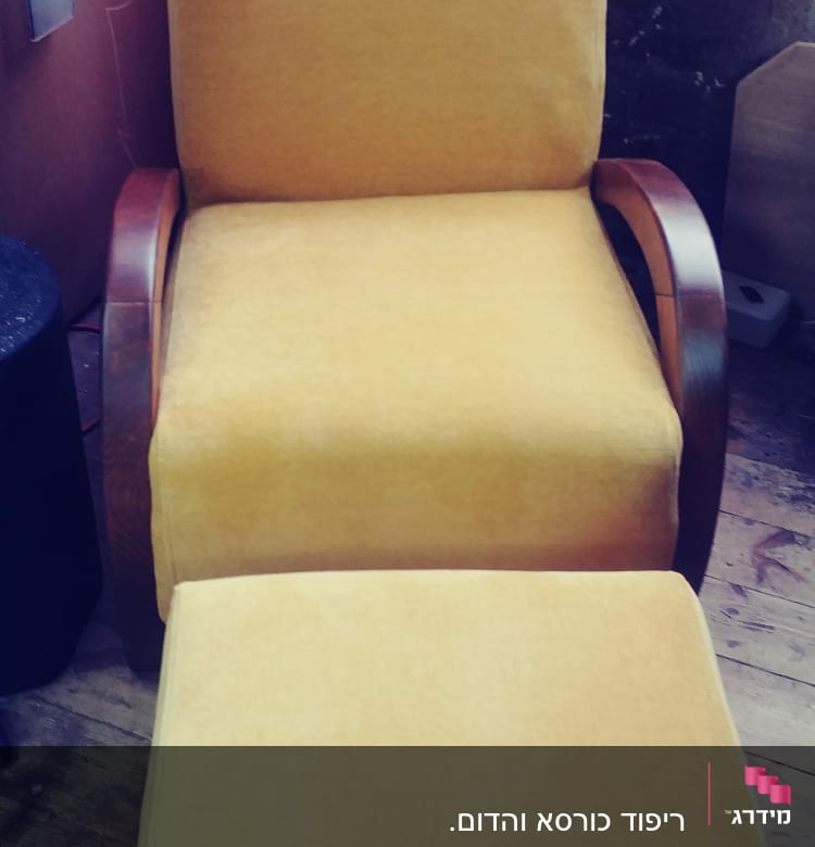 כורסה מרופדת בצבע צהוב עם הדום תואם